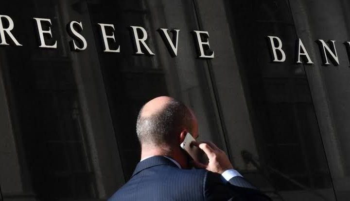 A man stands outside the Reserve Bank, reflecting the disconnect between economic decisions and everyday workers.